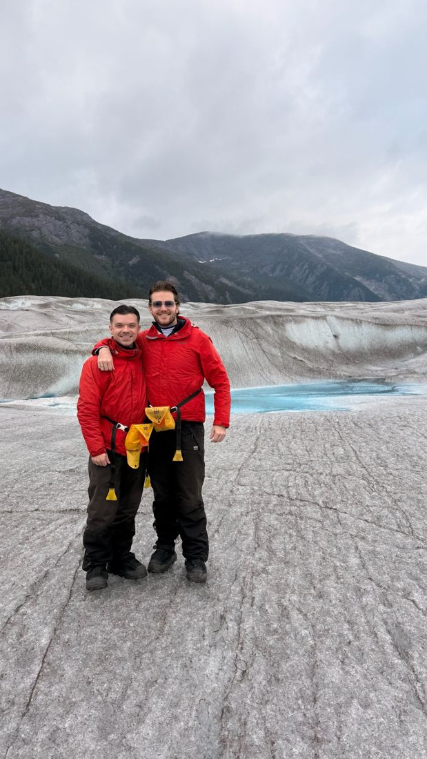Justin and his partner Chase standing on a glacier in Alaska